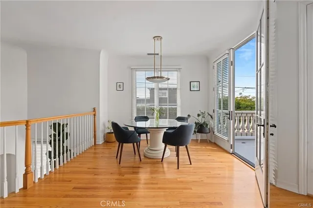 a dining room with wooden floor a chandelier a wooden table and chairs