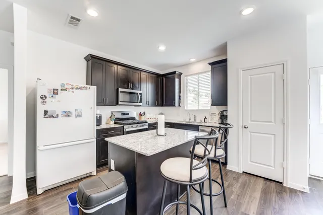 a kitchen with stainless steel appliances granite countertop a sink stove and microwave
