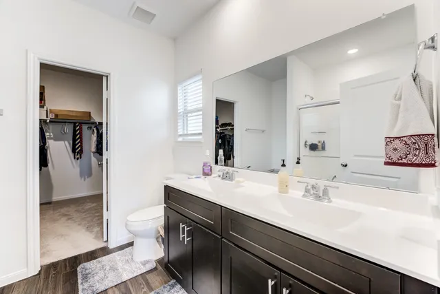 a bathroom with a double vanity sink toilet and shower