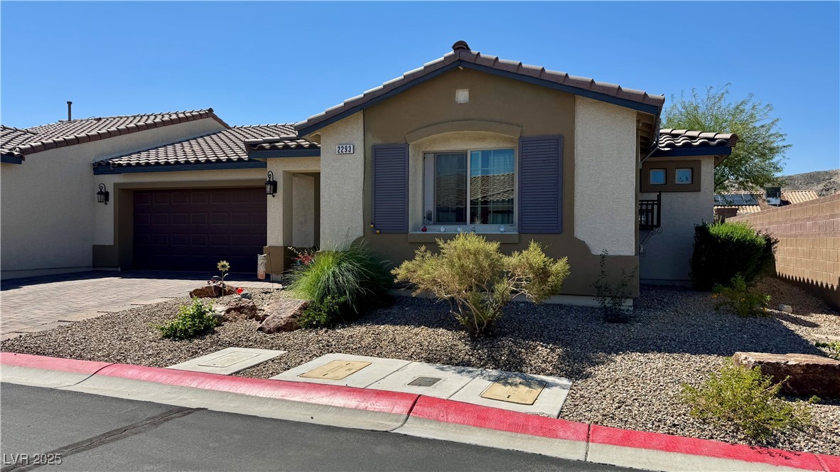 2293 Chandler Ranch Place Laughlin, NV 89029 - Photo 3 of 23 Mediterranean / spanish-style house featuring stucco siding, a garage, a tiled roof, and driveway