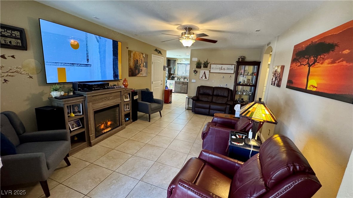 2293 Chandler Ranch Place Laughlin, NV 89029 - Photo 5 of 23 Tiled living area with a glass covered fireplace, arched walkways, and ceiling fan