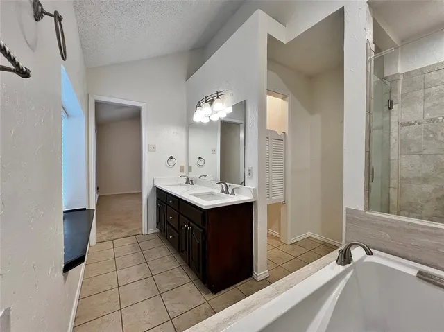 a spacious bathroom with a double vanity sink a mirror and a bathtub