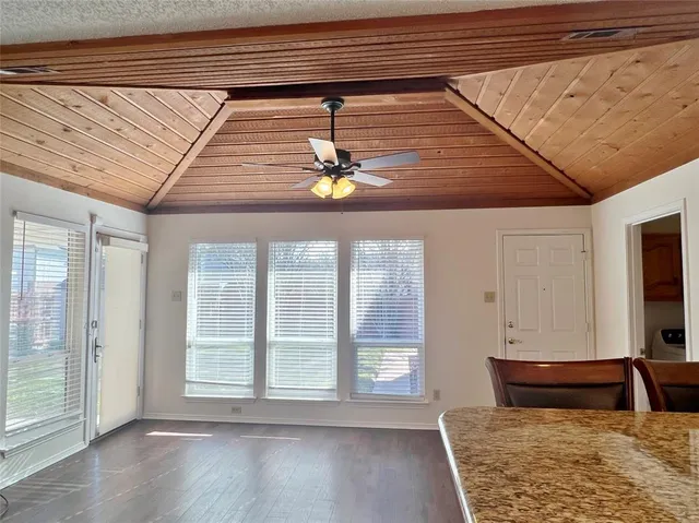 a view of a livingroom with wooden floor and a large window