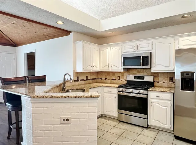 a kitchen with a stove microwave and white cabinets