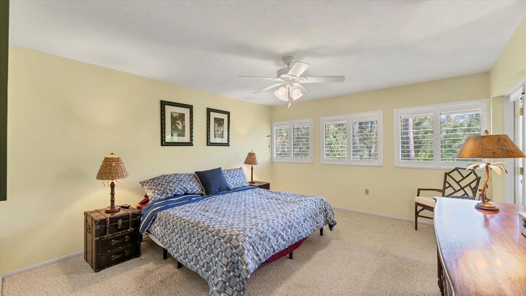 4957 Cross Creek Road, Unit 4957 Sarasota, FL 34231 - Photo 15 of 32 a bedroom with a large bed and a chandelier
