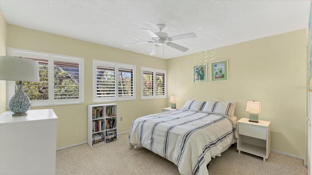 4957 Cross Creek Road, Unit 4957 Sarasota, FL 34231 - Photo 18 of 32 a bedroom with a bed a dresser and a window
