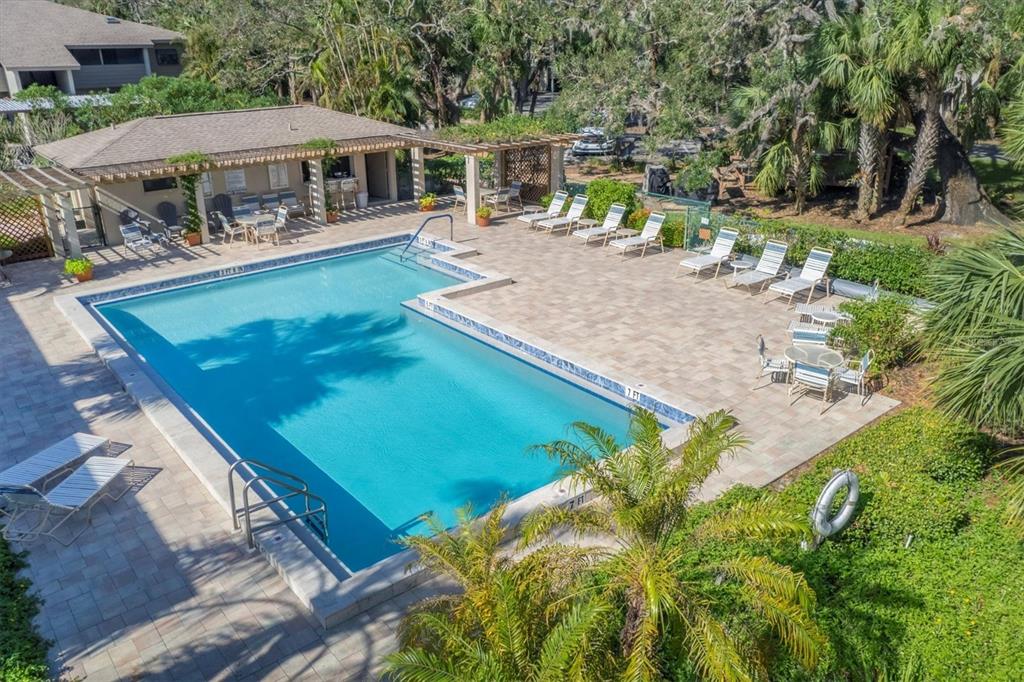 4957 Cross Creek Road, Unit 4957 Sarasota, FL 34231 - Photo 22 of 32 a view of a house with pool and chairs next to a yard