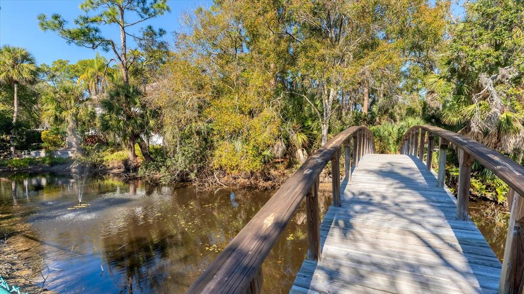 4957 Cross Creek Road, Unit 4957 Sarasota, FL 34231 - Photo 26 of 32 a balcony with wooden floor and trees