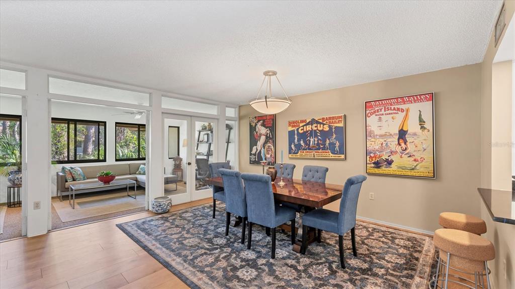 4957 Cross Creek Road, Unit 4957 Sarasota, FL 34231 - Photo 4 of 32 a dining room with wooden floor and a chandelier