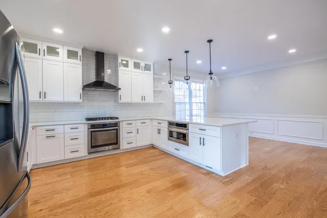 a kitchen with kitchen island white cabinets and refrigerator