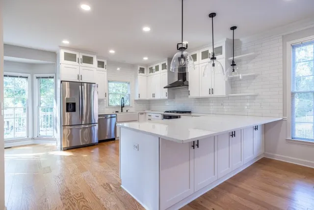 a kitchen with white cabinets and appliances