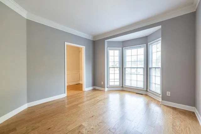 a view of empty room with a fireplace and wooden floor