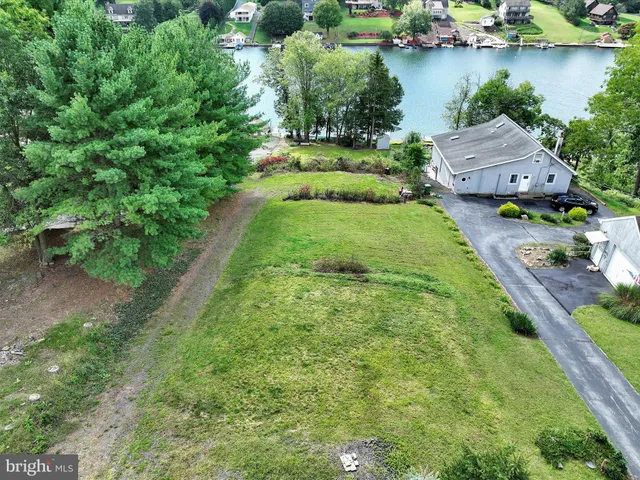 an aerial view of a house with outdoor space and lake view