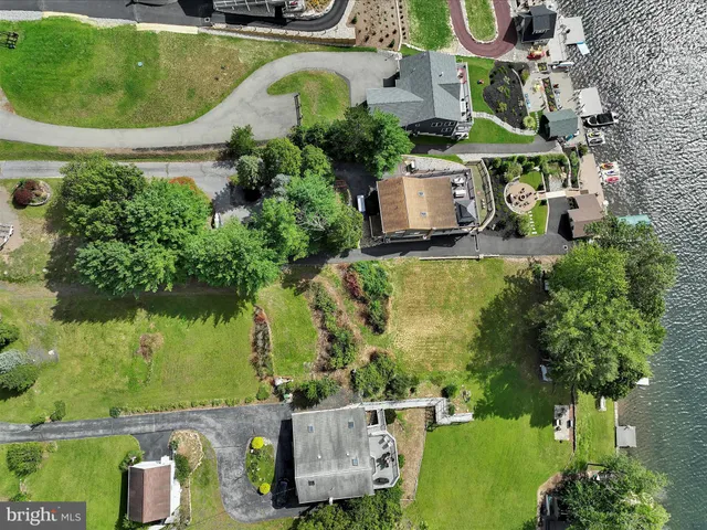 an aerial view of a house with a garden and lake view