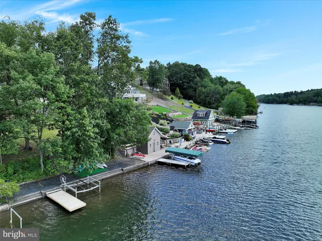 an aerial view of a house with a yard and lake view