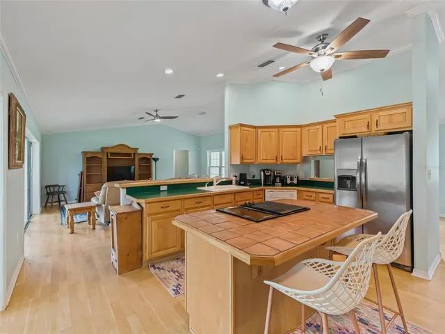 a kitchen that has a cabinets a sink and a stove with chairs