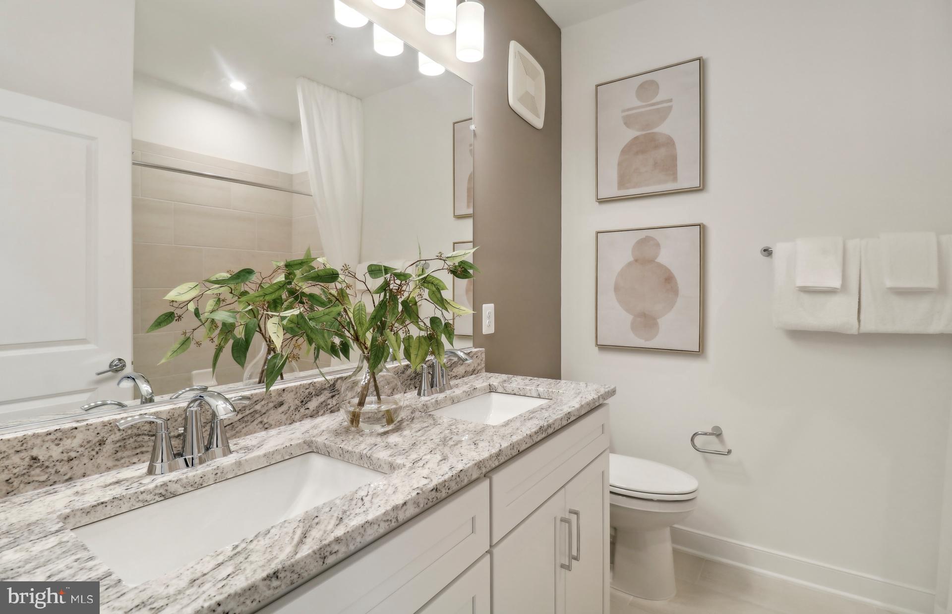 16096 Frederick Road Rockville, MD 20850 - Photo 14 of 35 a bathroom with a granite countertop sink and a mirror