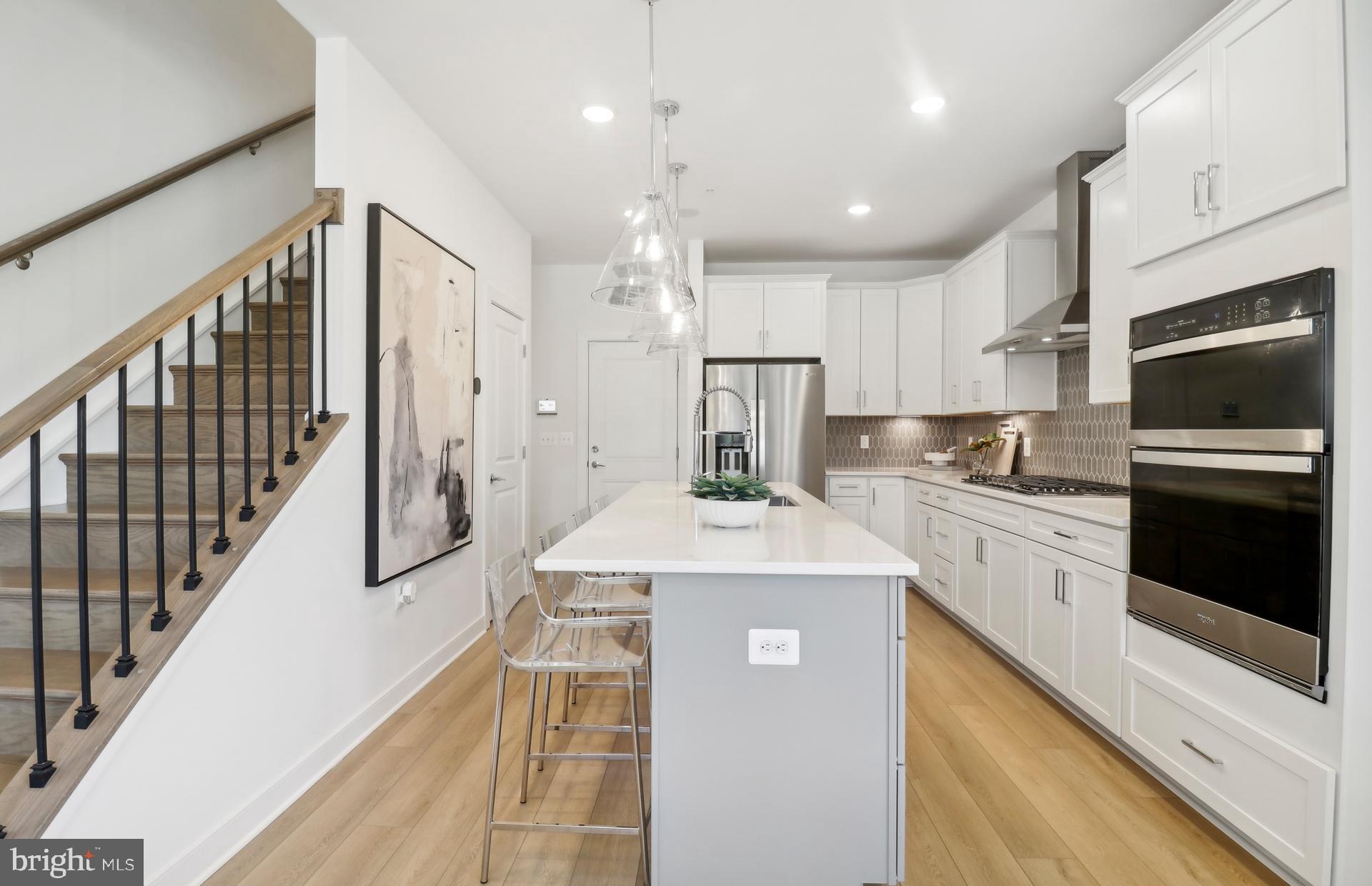 16096 Frederick Road Rockville, MD 20850 - Photo 6 of 35 a kitchen with stainless steel appliances kitchen island granite countertop a refrigerator a stove a sink and white cabinets with wooden floor