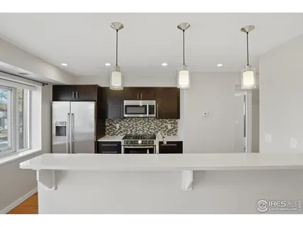 a kitchen with kitchen island a counter top space stainless steel appliances and cabinets