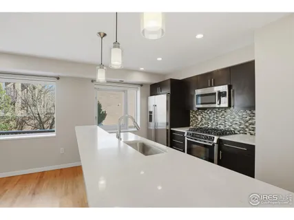 a kitchen with stainless steel appliances kitchen island granite countertop a stove and a refrigerator
