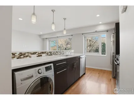a kitchen that has a lot of cabinets in it with wooden floor