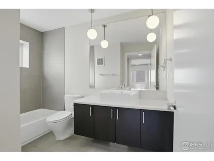 a bathroom with a sink a toilet a mirror and shower