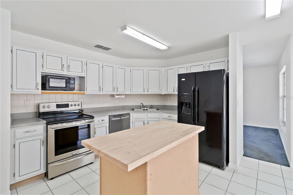 7771 Indian Ridge Trail North Kissimmee, FL 34747 - Photo 11 of 51 a kitchen with a stove a sink and a refrigerator