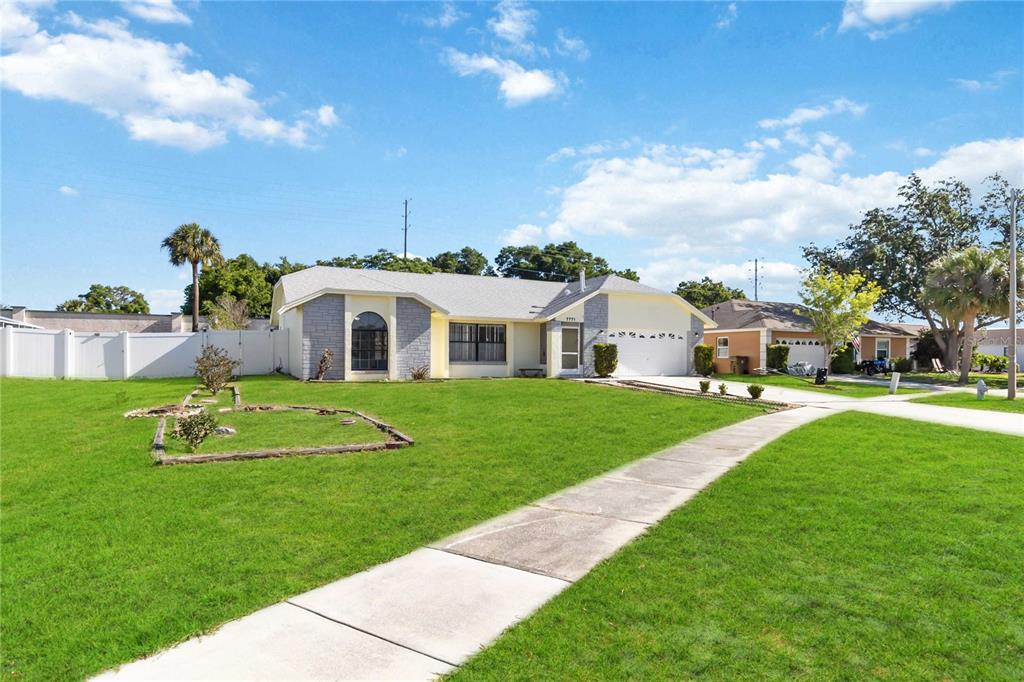 7771 Indian Ridge Trail North Kissimmee, FL 34747 - Photo 3 of 51 a white house with a big yard and potted plants