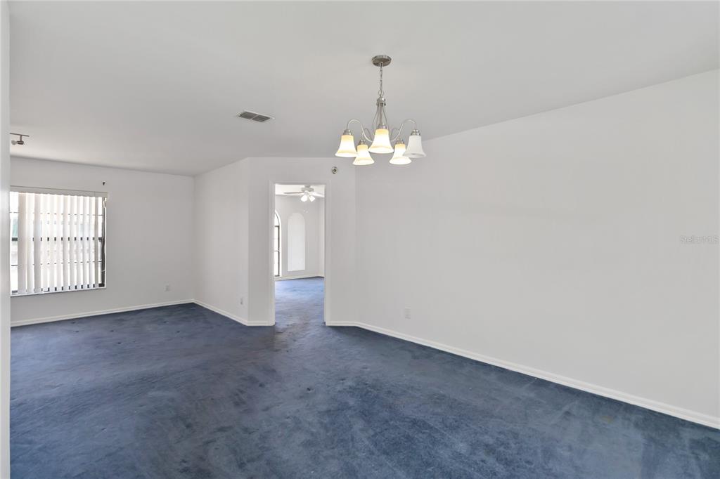 7771 Indian Ridge Trail North Kissimmee, FL 34747 - Photo 10 of 51 an empty room with chandelier and windows