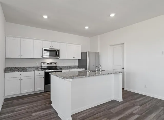 a kitchen with stainless steel appliances granite countertop a stove a sink and a refrigerator