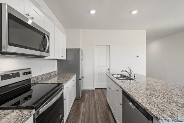 a kitchen with a sink stove and microwave