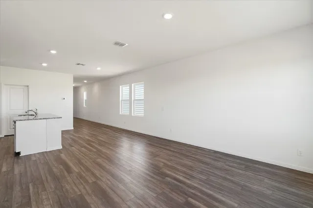 a view of a kitchen with wooden floor and a window