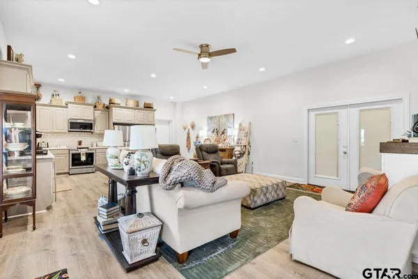 a living room with furniture kitchen view and a chandelier