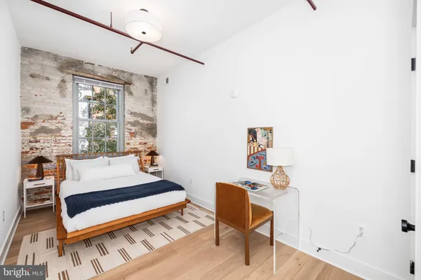 a bedroom with a bed a chair and a large window