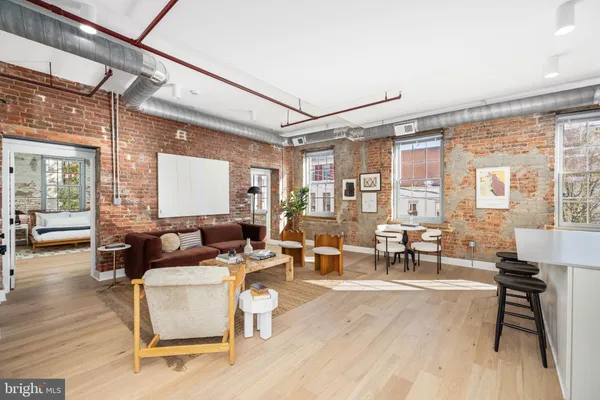 a living room with furniture a table and large windows
