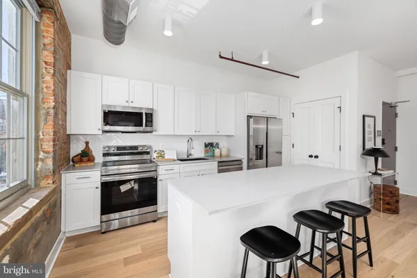 a kitchen with stainless steel appliances a stove refrigerator sink and microwave