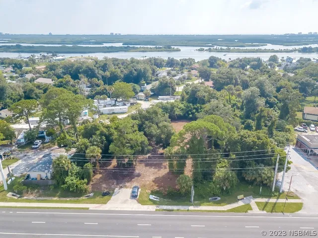 an aerial view of residential houses with outdoor space and ocean view