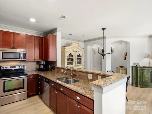 a kitchen with stainless steel appliances granite countertop a sink and stove top oven