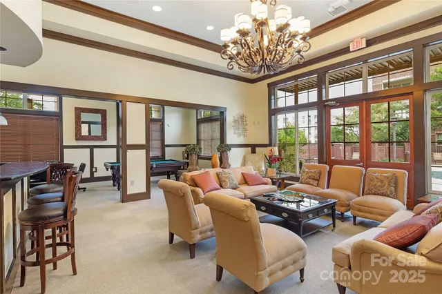 a living room with furniture a chandelier and a dining table