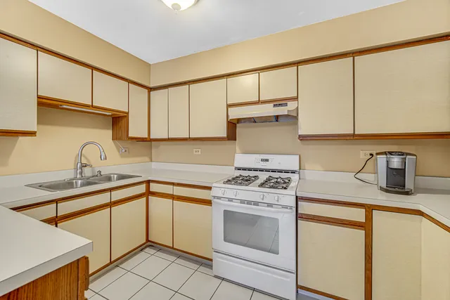 a kitchen with a sink stove top oven and cabinets