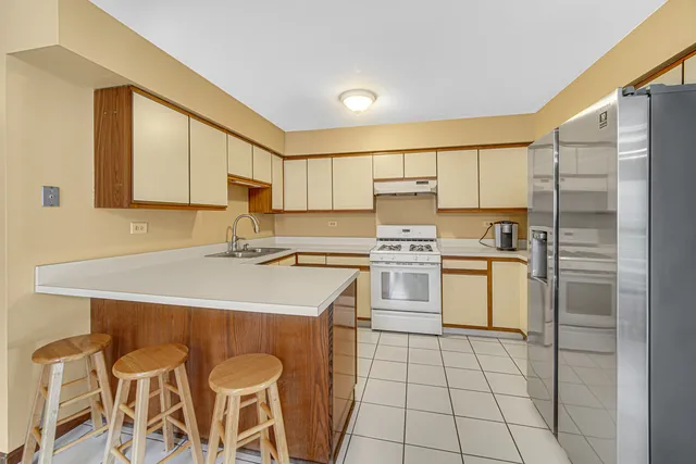 a kitchen with a sink a stove a refrigerator and white cabinets
