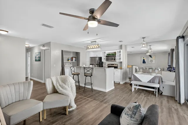 a living room with furniture a dining table and kitchen view