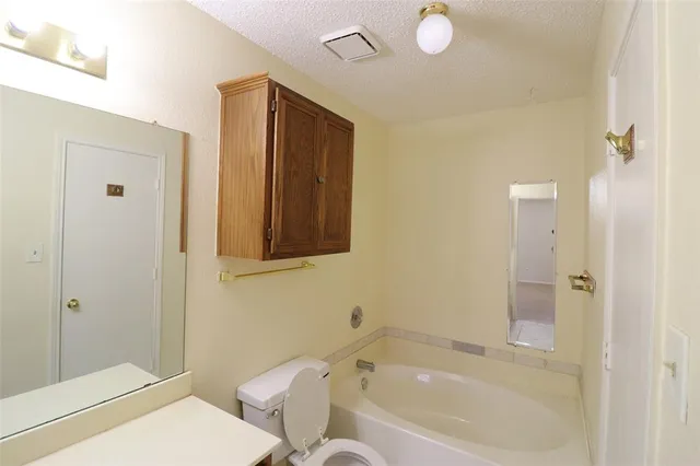 a bathroom with a tub sink and mirror
