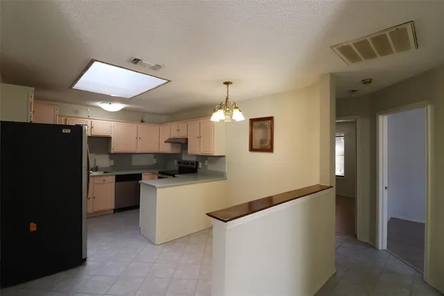 a kitchen with a refrigerator and a stove top oven