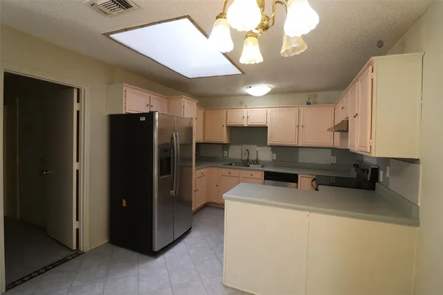 a kitchen with refrigerator and cabinets