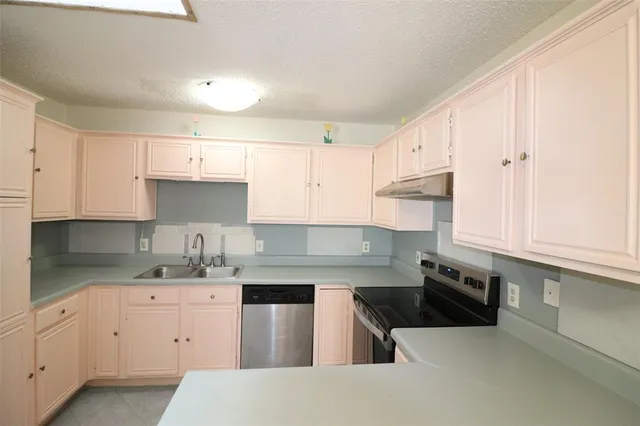 a kitchen with a sink a stove and cabinets