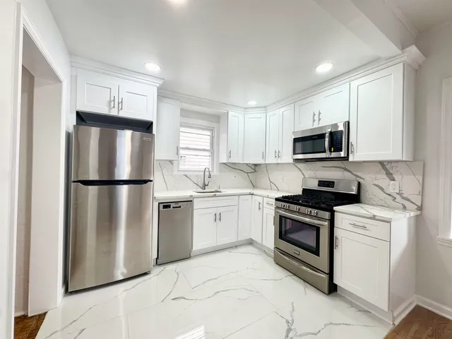 a kitchen with stainless steel appliances granite countertop a refrigerator stove a sink and microwave