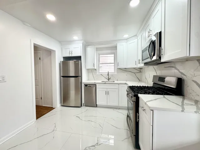 a kitchen with a refrigerator sink and cabinets