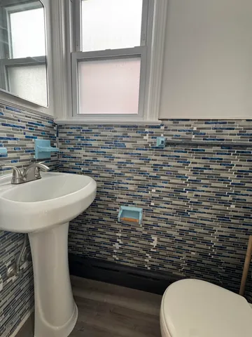 a bathroom with a toilet sink and mirror