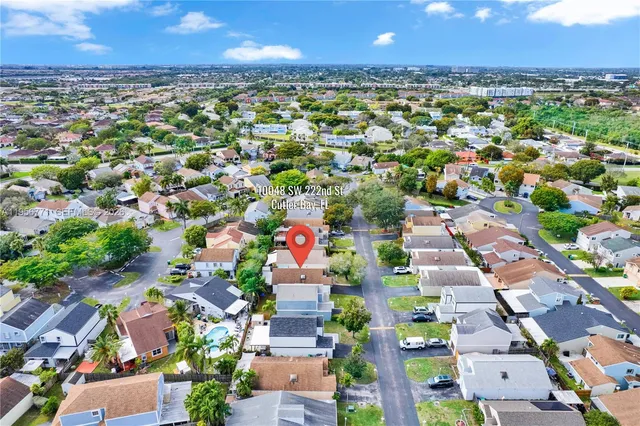 an aerial view of residential houses with outdoor space and trees